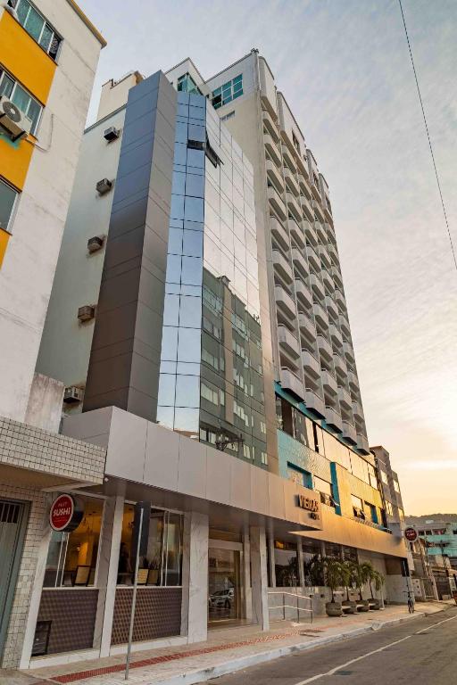 Fachada moderna do Hotel Vieiras com janelas espelhadas em uma rua da cidade.
